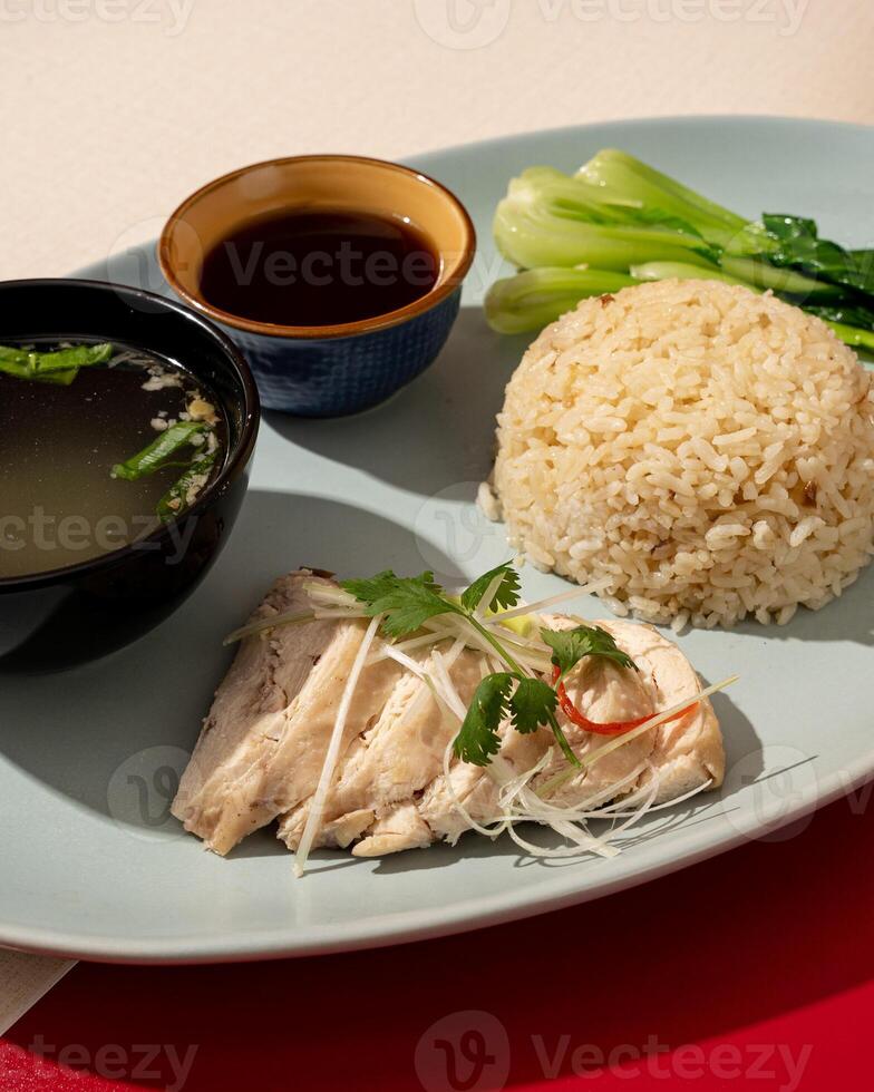 Hainanese chicken rice is a dish consisting of delicious steamed white chicken cut into pieces and served over fragrant rice photo