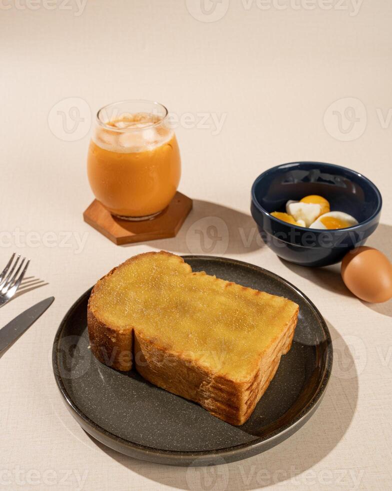 Roti Bakar is a typical grilled Indonesian sandwich, consisting of two slices of bread and filling, served with Teh Tarik and boiled egg. photo