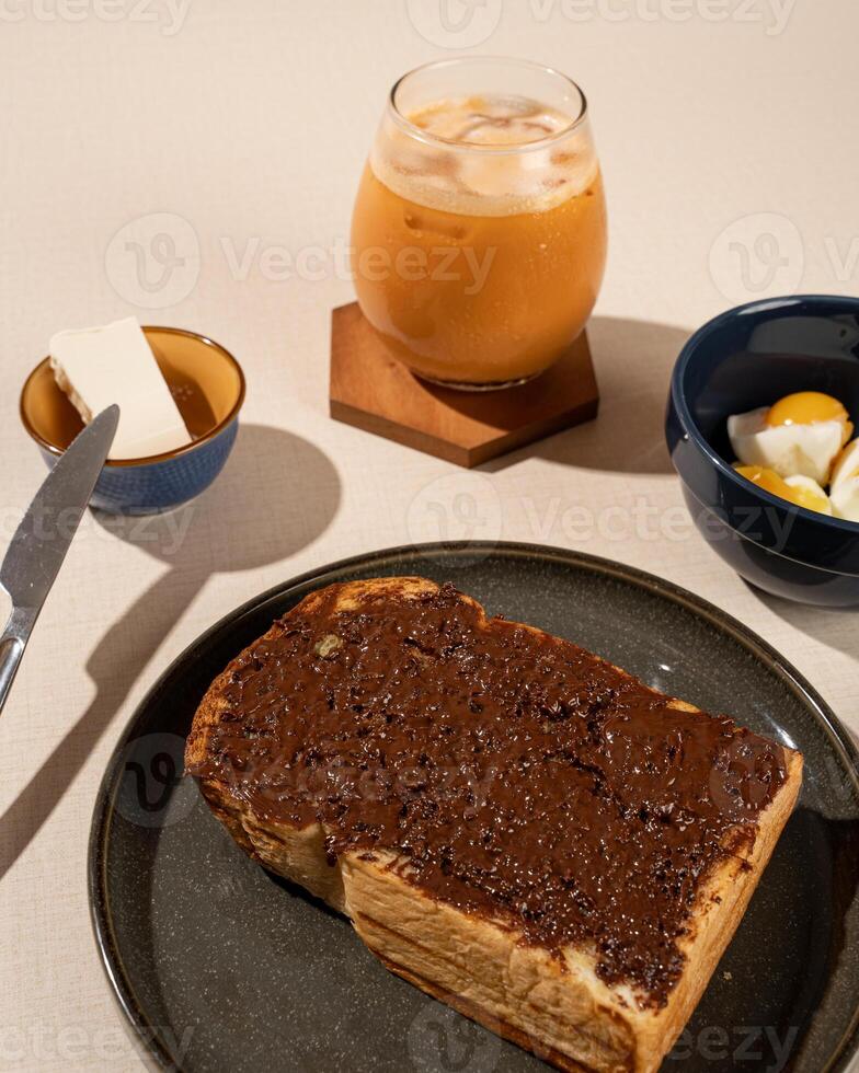 Roti Bakar is a typical grilled Indonesian sandwich, consisting of two slices of bread and filling, served with Teh Tarik and boiled egg. photo