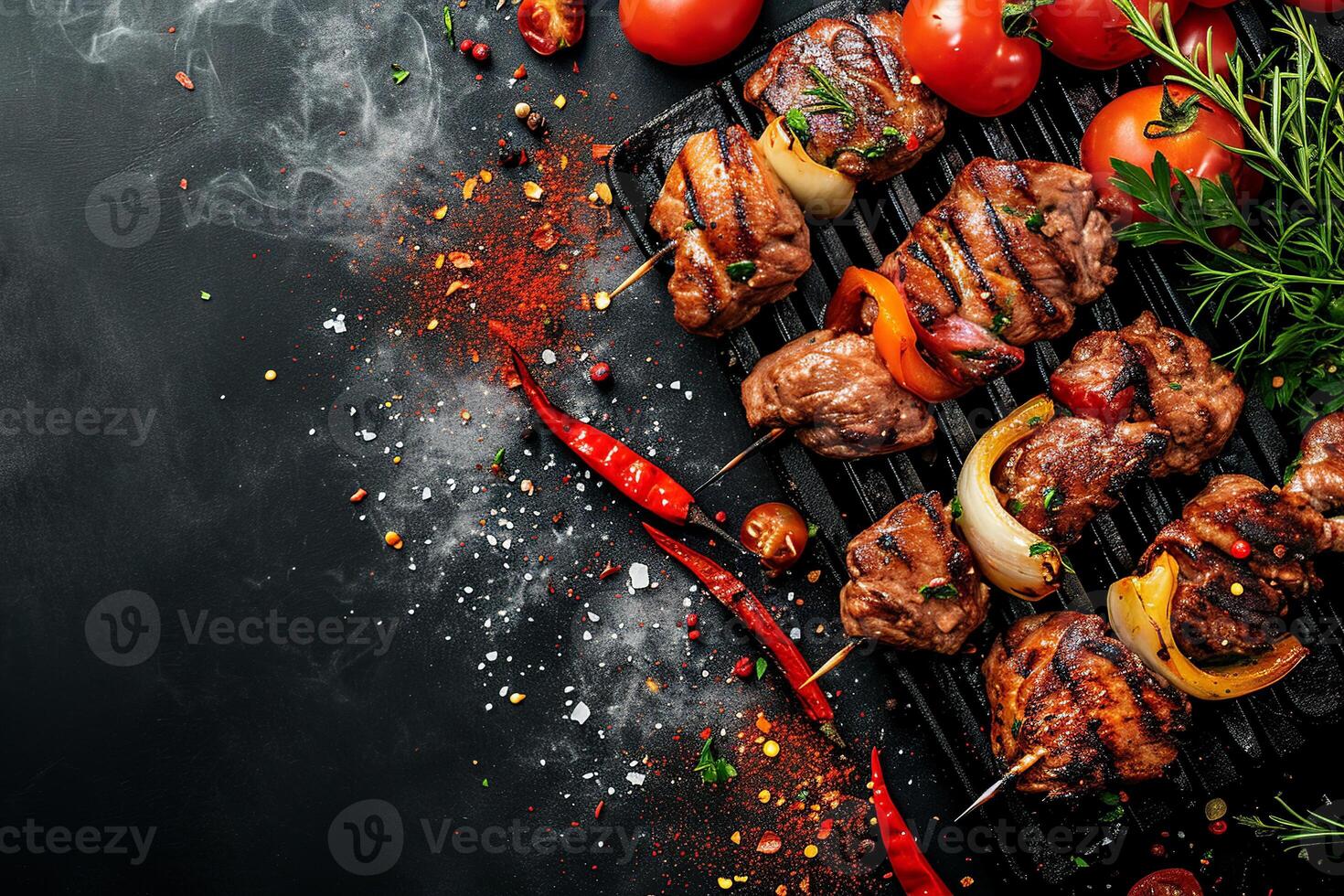 Meat grilled on skewers with onions and tomatoes, chili. Top view bbq concept with copy space. Grill food on dark background photo