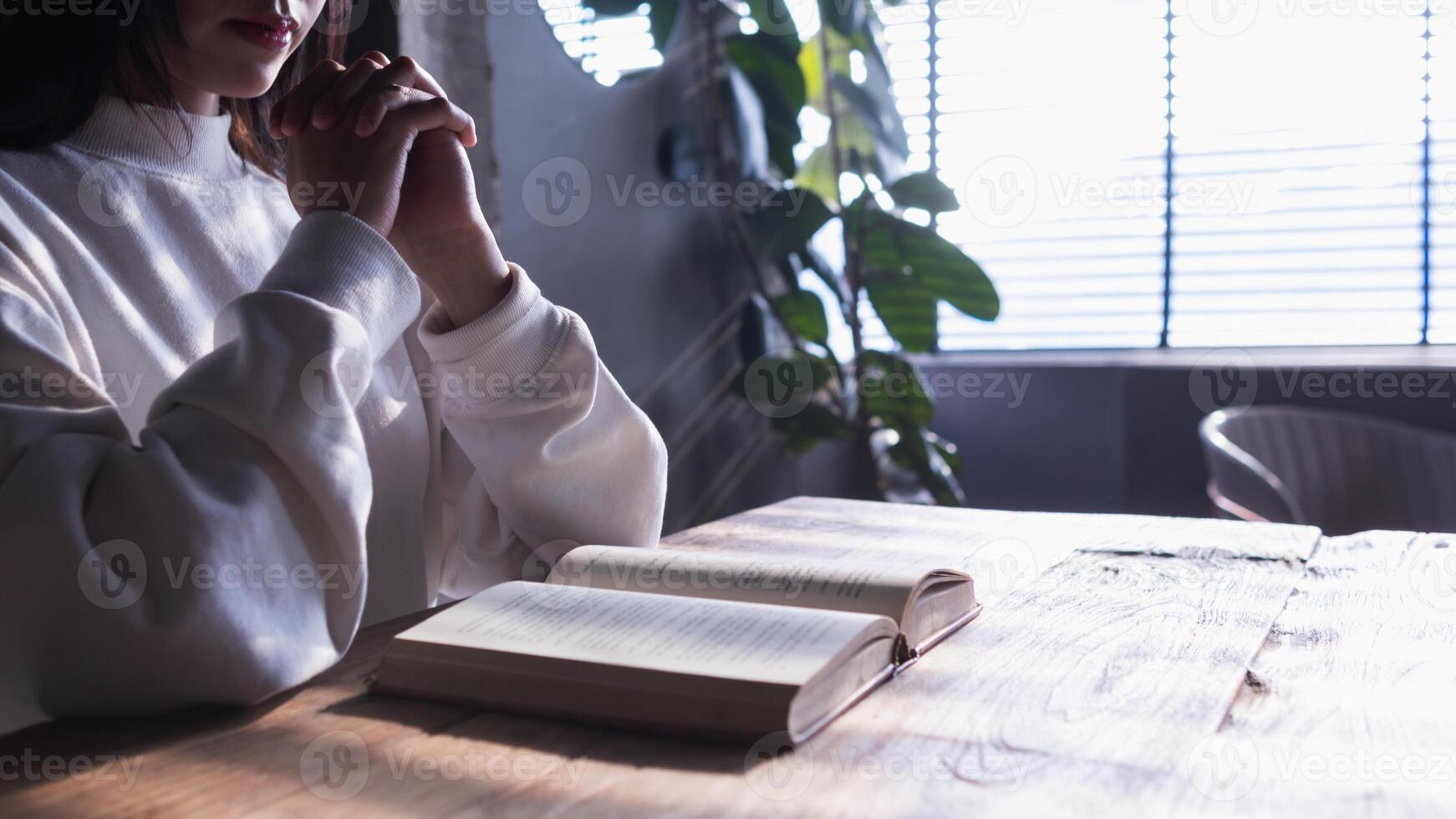 The young woman held a Bible in her hand and tried to learn and understand God teachings from the Bible she held. Concepts of belief and the power of faith in God and teachings from the Bible. photo