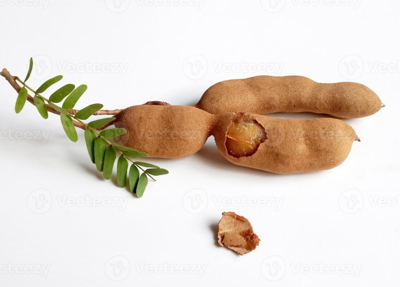 Ripe tamarind fruits with leaves isolated on white background photo