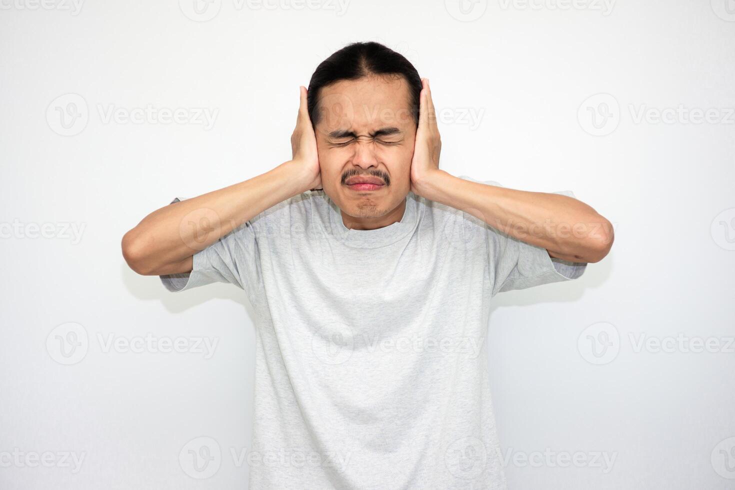 The Asian man was very upset and covered both ears with both hands. white isolation background photo