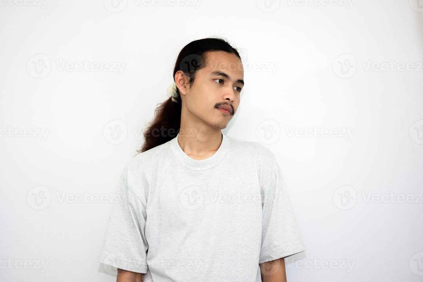 Asian man wearing gray tshirt and long hair making lazy expression after waking up. isolated in white background photo
