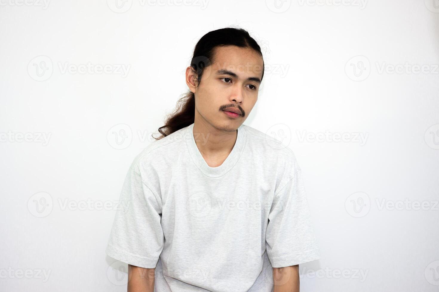 Asian man wearing gray tshirt and long hair making lazy expression after waking up. isolated in white background photo