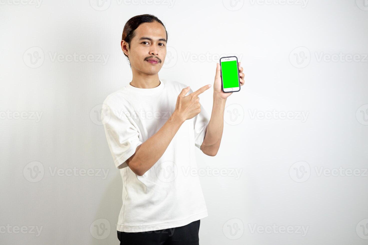 Asian man holding cell phone. pointed to the side and pointed at his cellphone. isolated in white background photo
