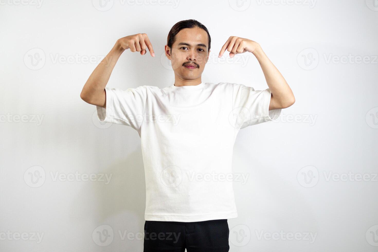 Asian man in white t-shirt pointing down. isolated on white studio background. photo