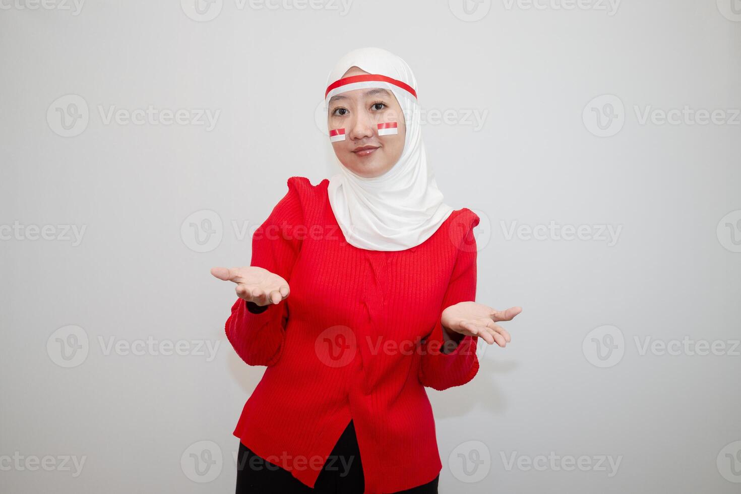 Woman in white hijab wearing red sweater. celebrating Indonesia's independence day. with an expression of offering. isolation on white background. photo
