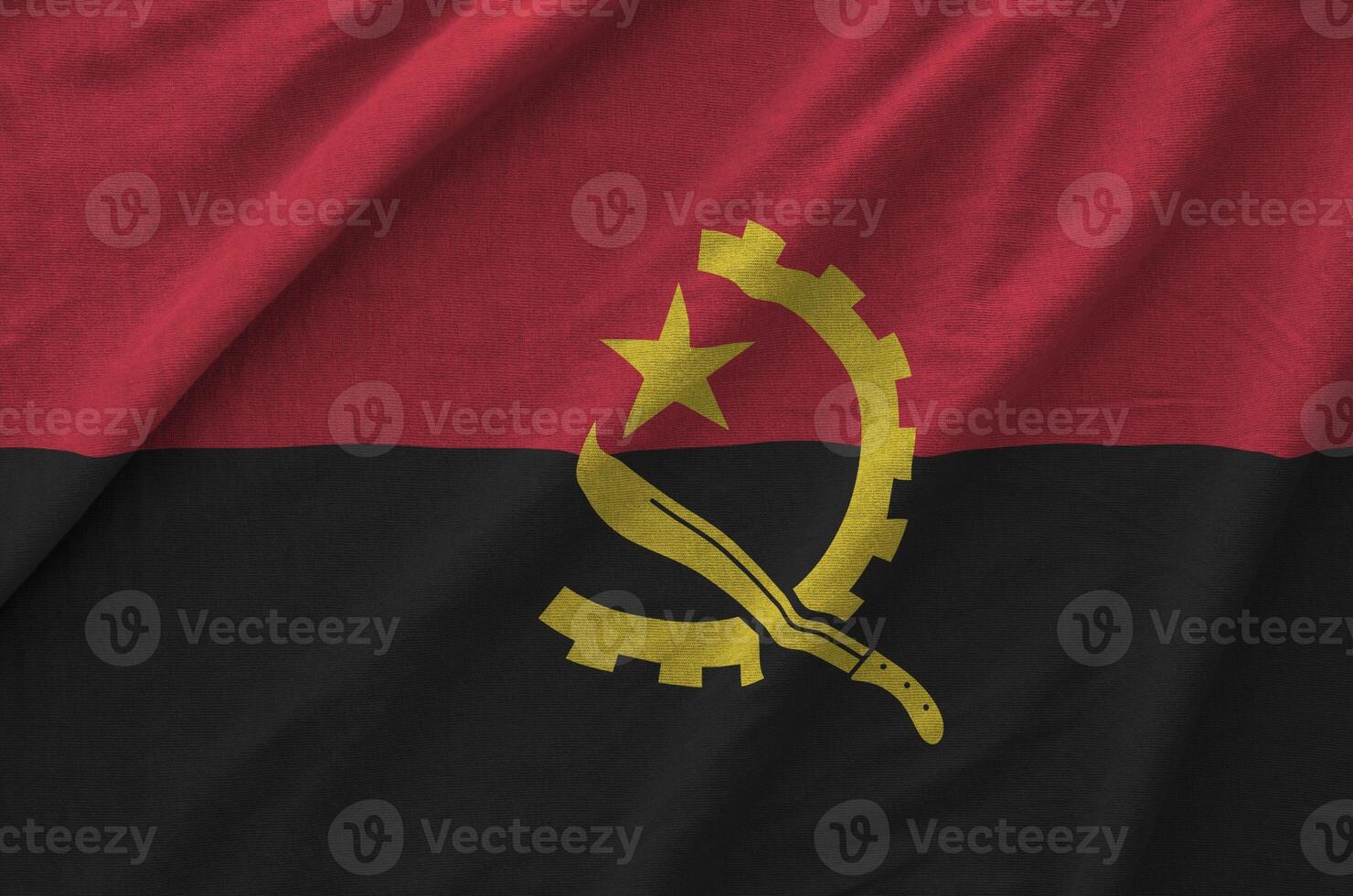 Angola flag depicted on folded wavy fabric of old cloth photo