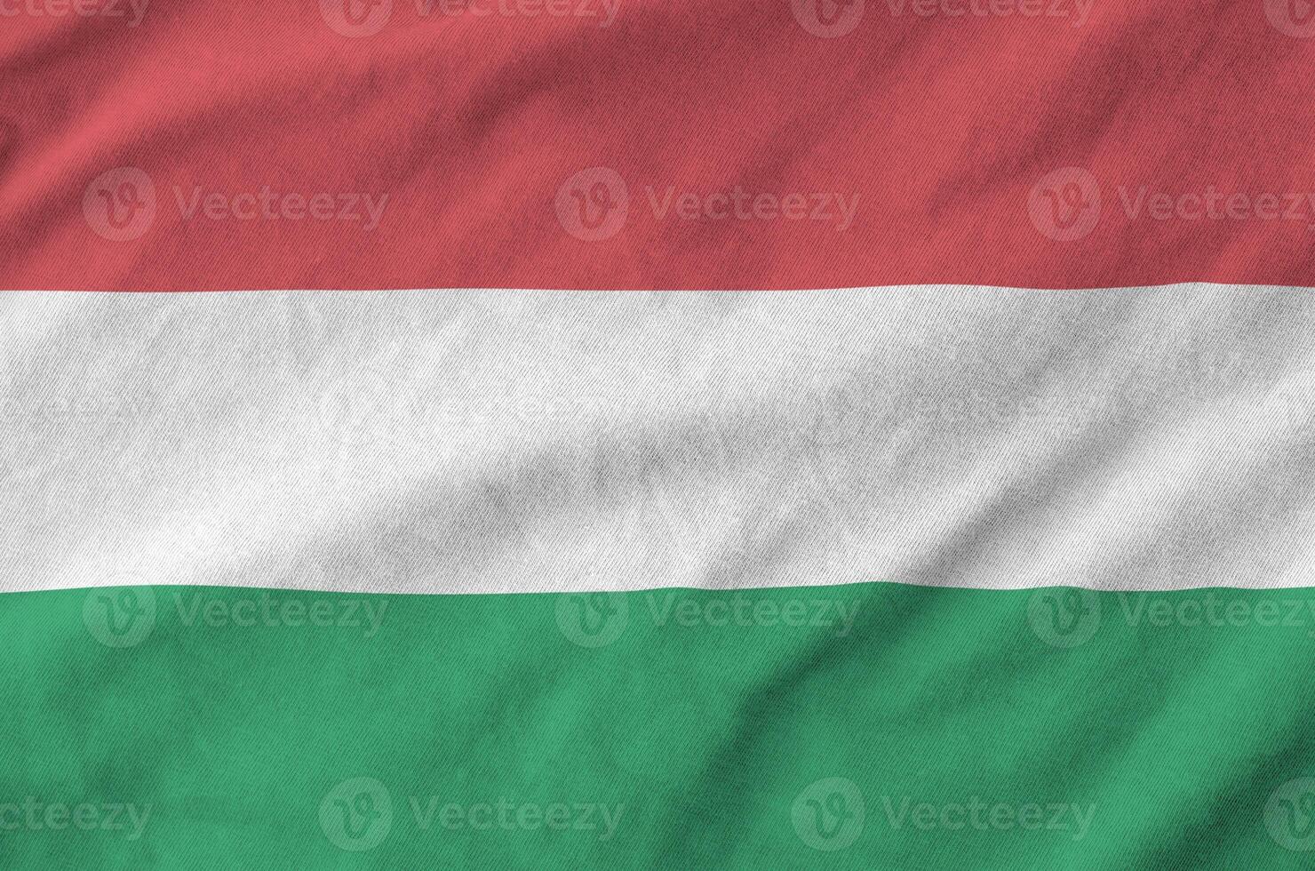 Hungary flag depicted on folded wavy fabric of old cloth photo