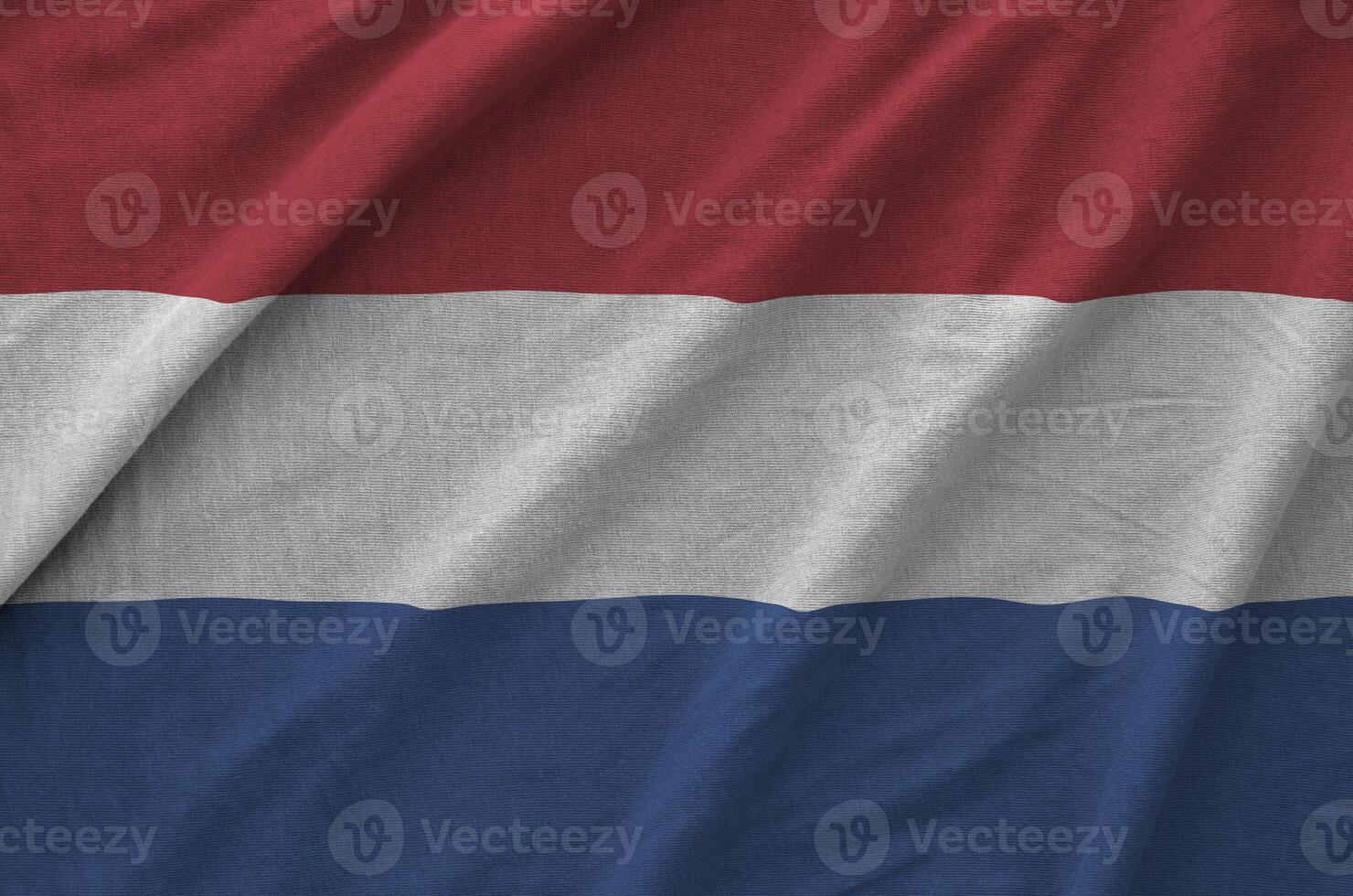 Netherlands flag depicted on folded wavy fabric of old cloth photo