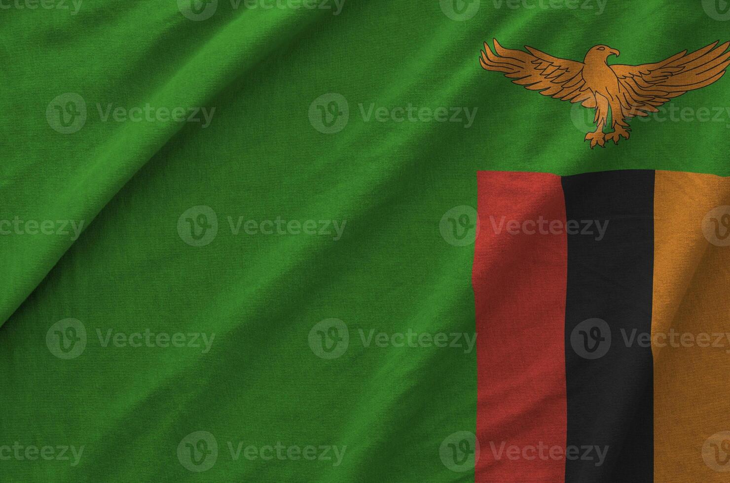 Zambia flag depicted on folded wavy fabric of old cloth photo