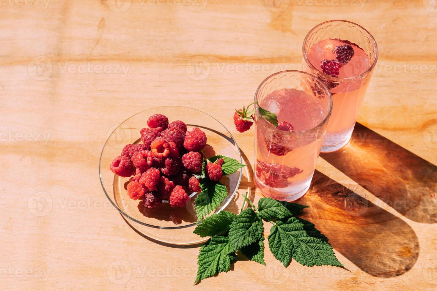 Ripe red raspberry drink in a transparent glass wooden background, summer seasonal food and refreshing drinks photo