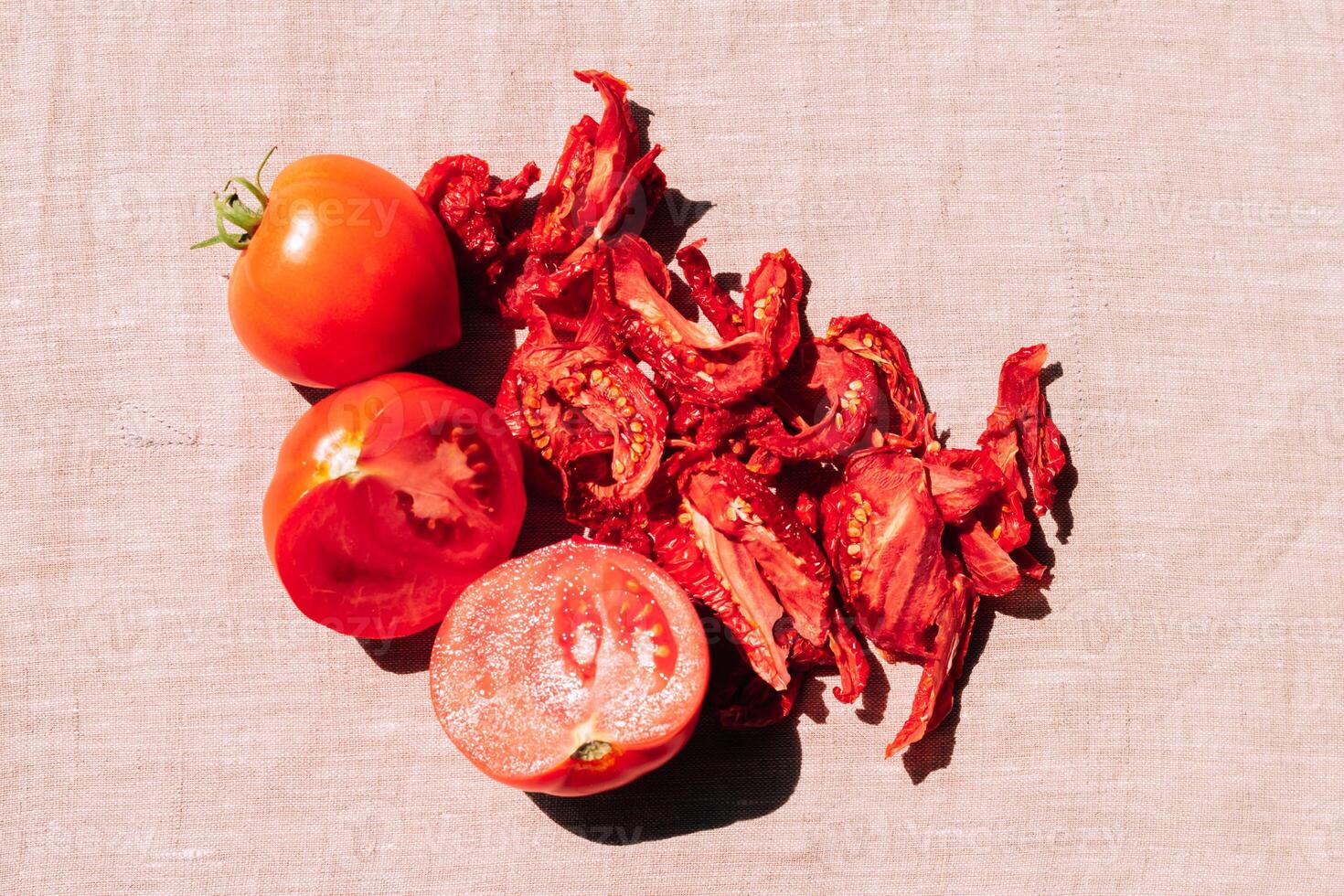 Fresh and dried tomatoes lie on the kitchen table, top view. Harvesting and processing of vegetables, vegetarianism photo