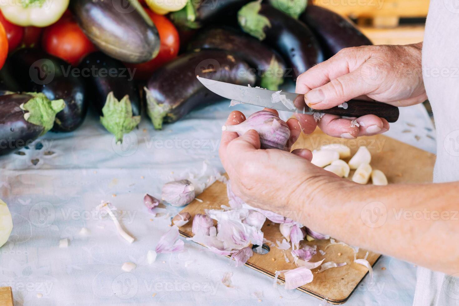 A woman is engaged in the preparation and processing of various fresh farm vegetables photo