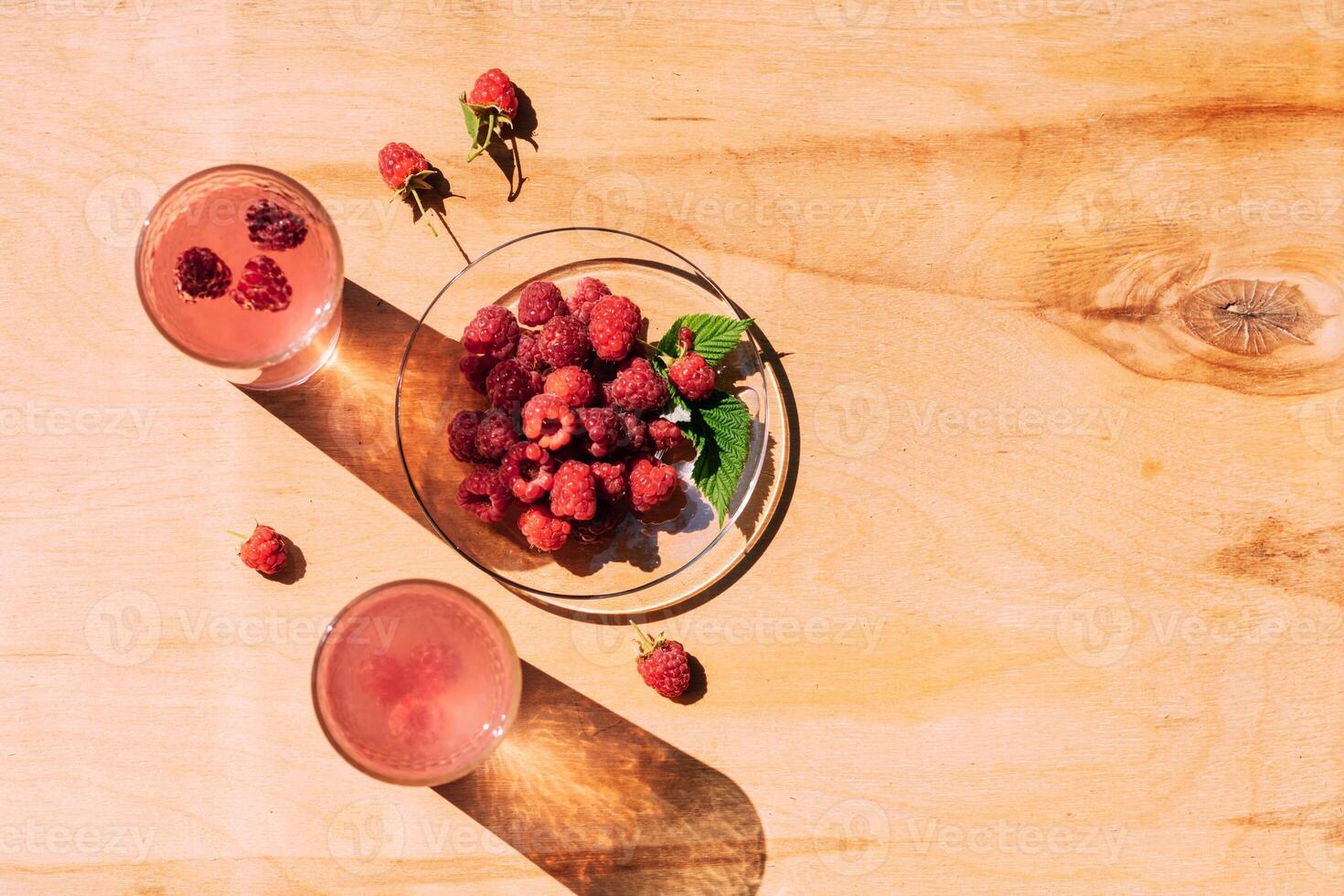 Ripe red raspberry drink in a transparent glass wooden background, summer seasonal food and refreshing drinks photo