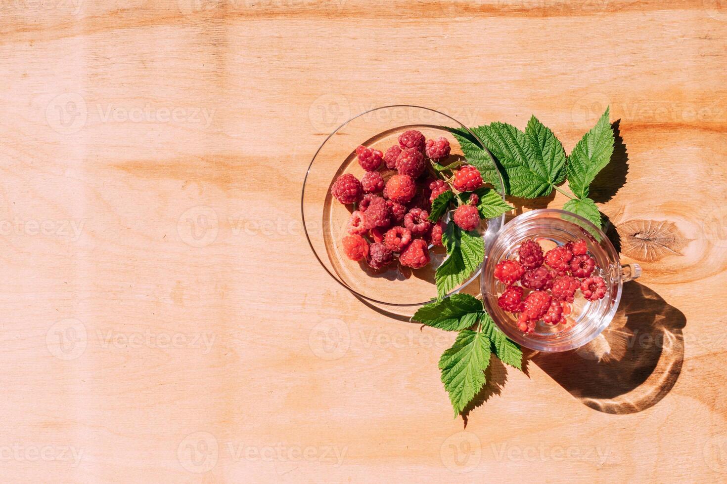 Ripe red raspberry drink in a transparent glass wooden background, summer seasonal food and refreshing drinks photo