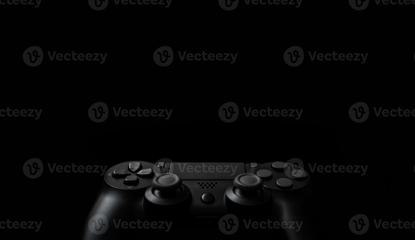 Modern black gamepad on a dark background. Game concept with copy space for text or design. photo