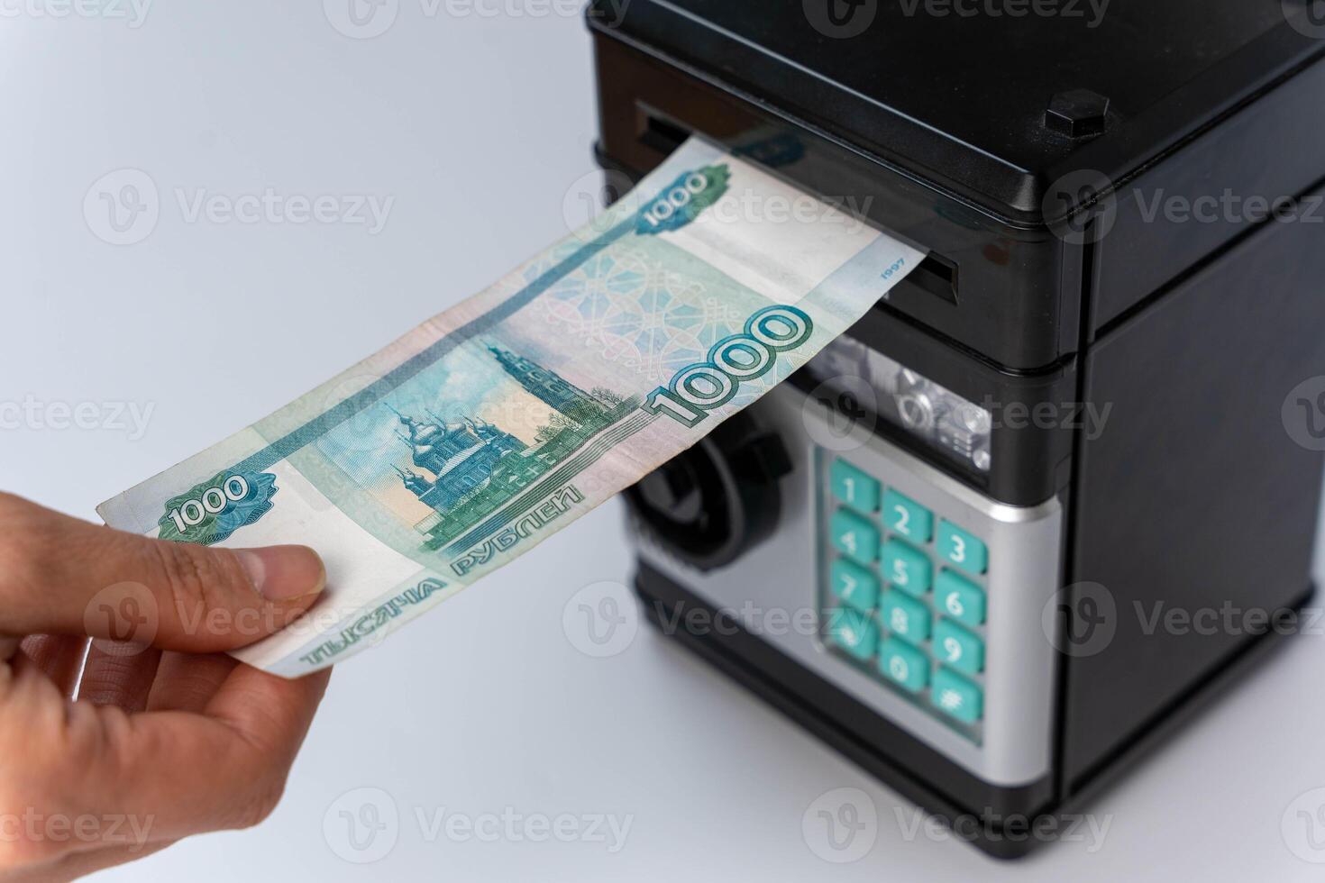 Individual inserting cash into automated teller machine. photo