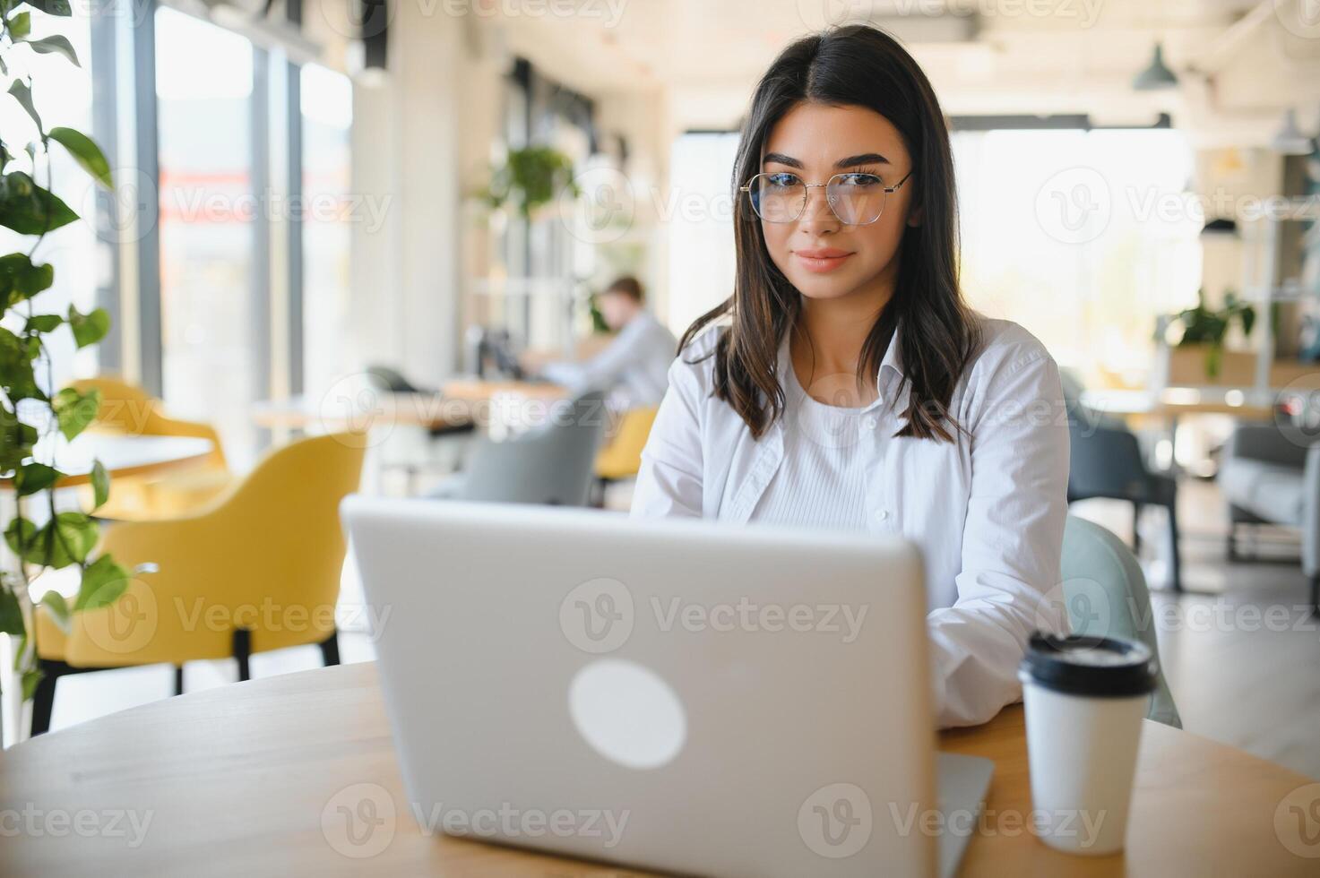 Smiling girl student study online with skype teacher, happy young woman learn language listen lecture watch webinar write notes look at laptop sit in cafe, distant education photo