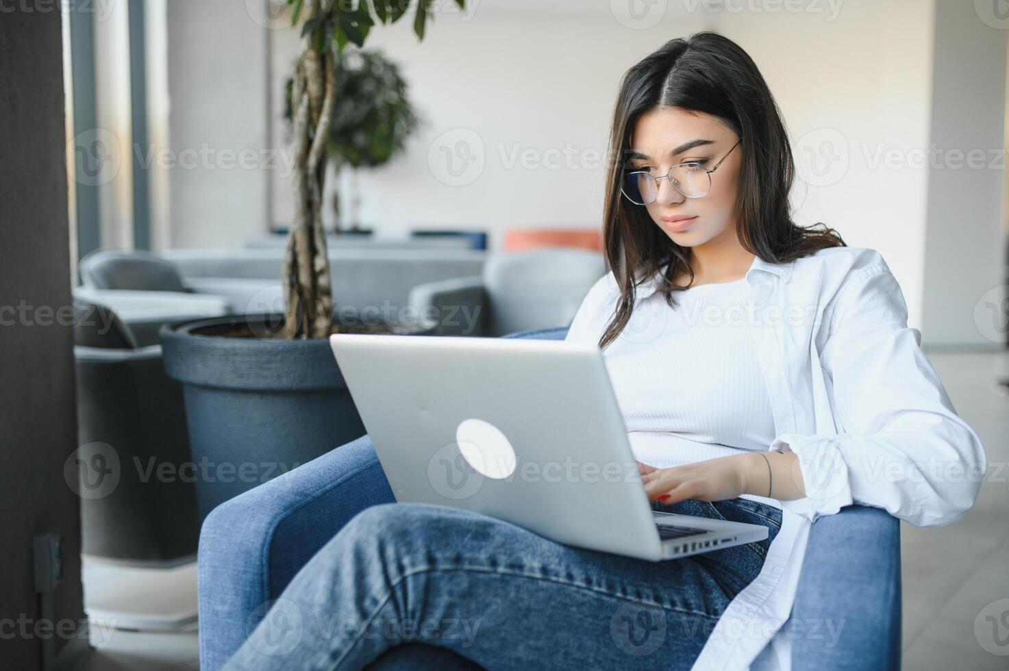Beautiful Caucasian woman dreaming about something while sitting with portable net-book in modern cafe bar, young charming female freelancer thinking about new ideas during work on laptop computer photo