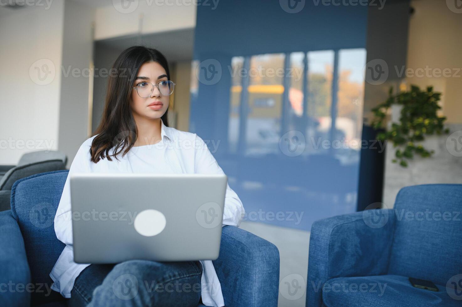 Joyful girl student studying online at cafe, using laptop and earphones, empty space photo