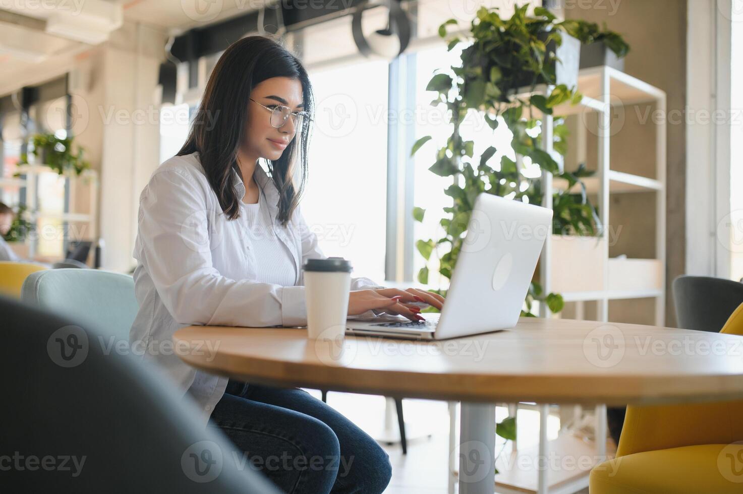 Smiling girl student study online with skype teacher, happy young woman learn language listen lecture watch webinar write notes look at laptop sit in cafe, distant education photo