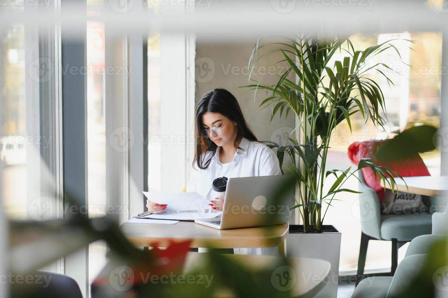 Smiling girl student study online with skype teacher, happy young woman learn language listen lecture watch webinar write notes look at laptop sit in cafe, distant education photo