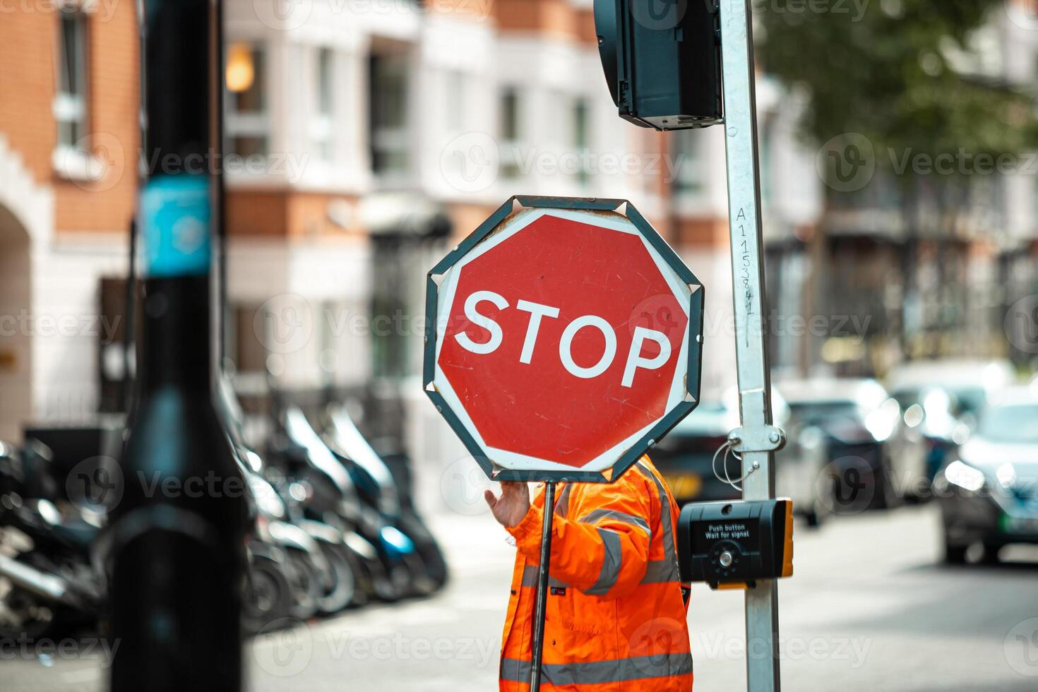 Road Construction Worker Holding a Stop Sign to Control Traffic Flow and Ensure Safety at Worksite photo