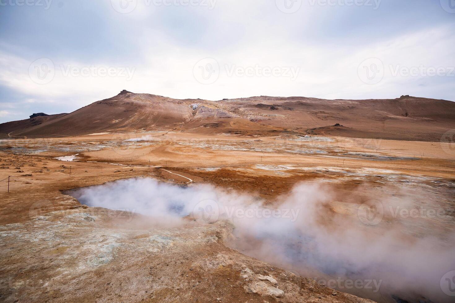 Boiling mudpots in the geothermal area Hverir and cracked ground around. Location geothermal area Hverir, Myvatn region, North part of Iceland photo