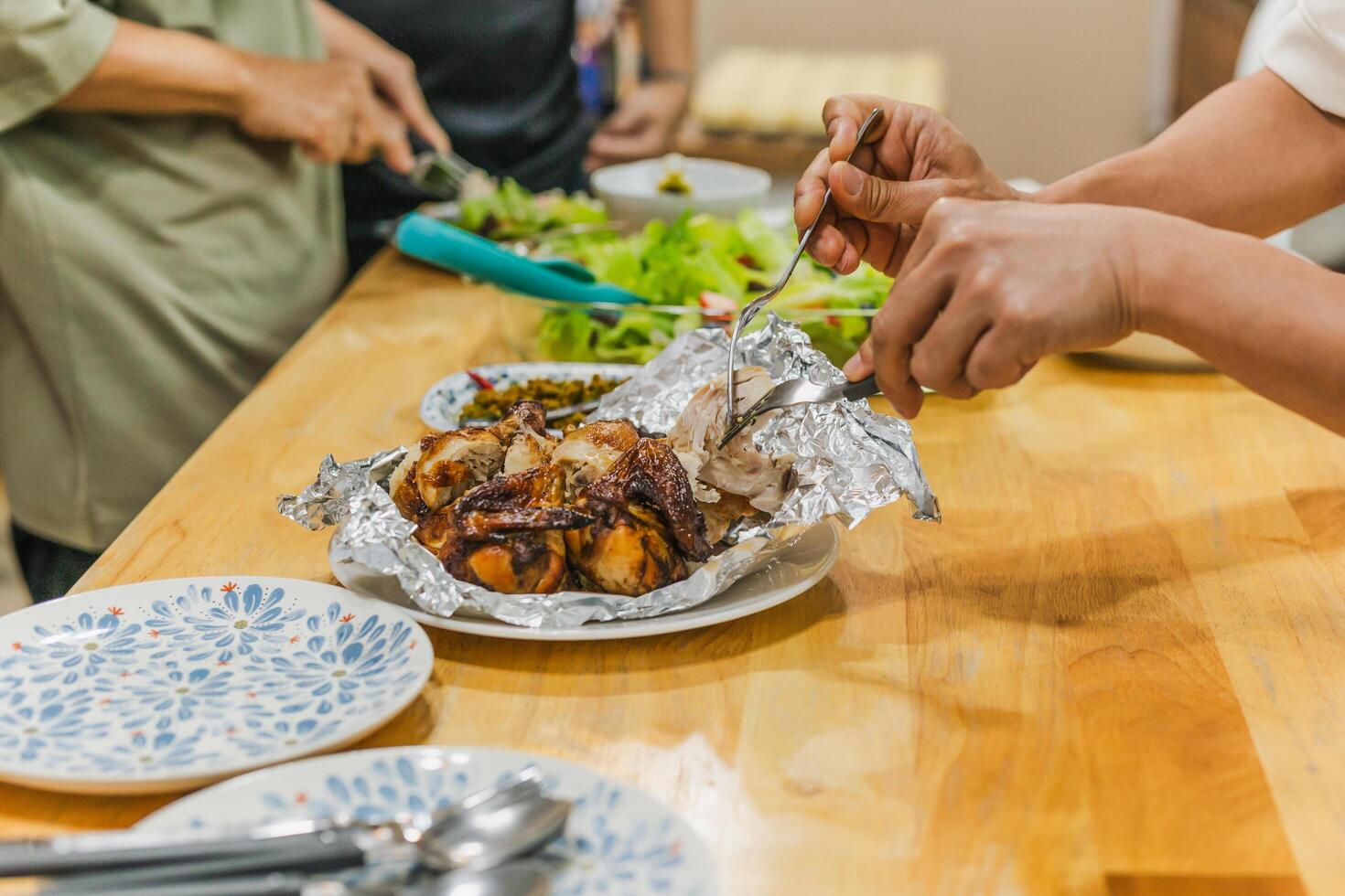 Group of friends enjoying roasted chicken dinner and vegetable salad. photo