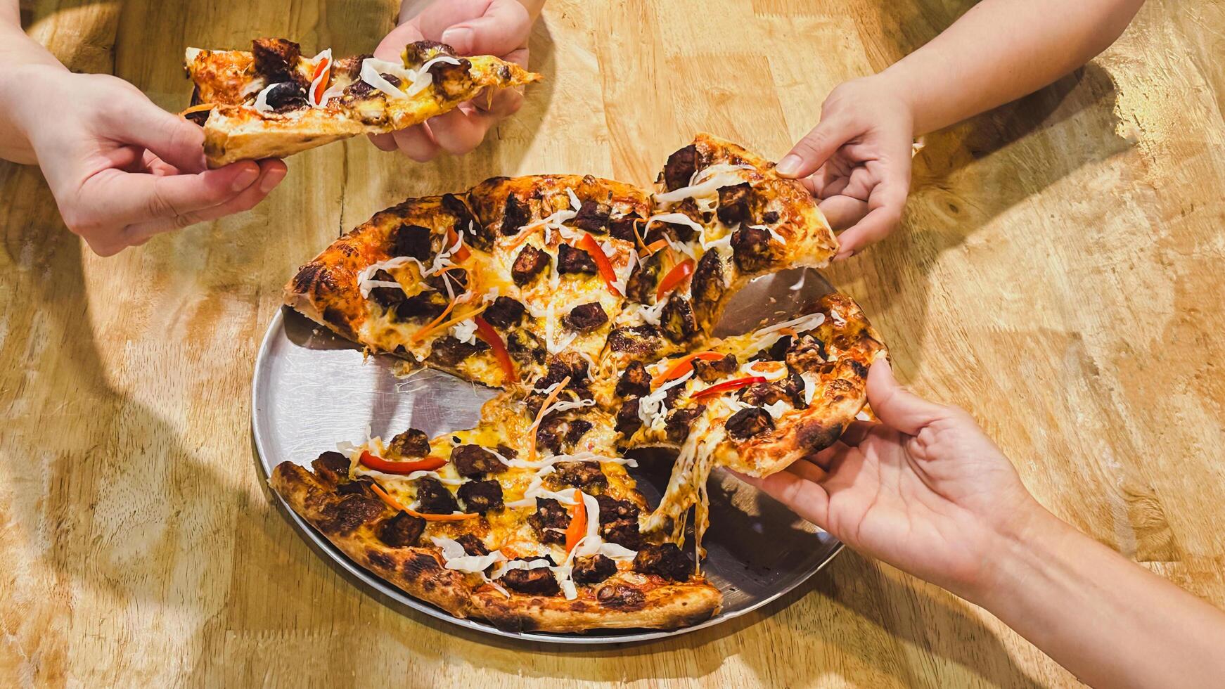 People hand taking slices of pizza in a restaurant. photo