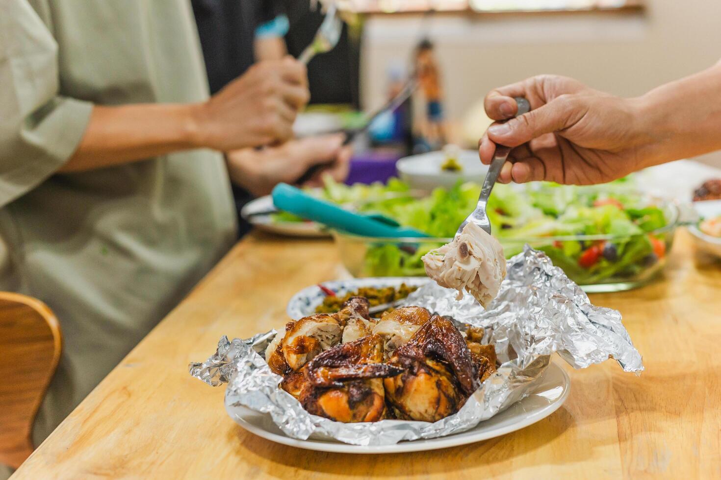 Group of friends enjoying roasted chicken dinner and vegetable salad. photo
