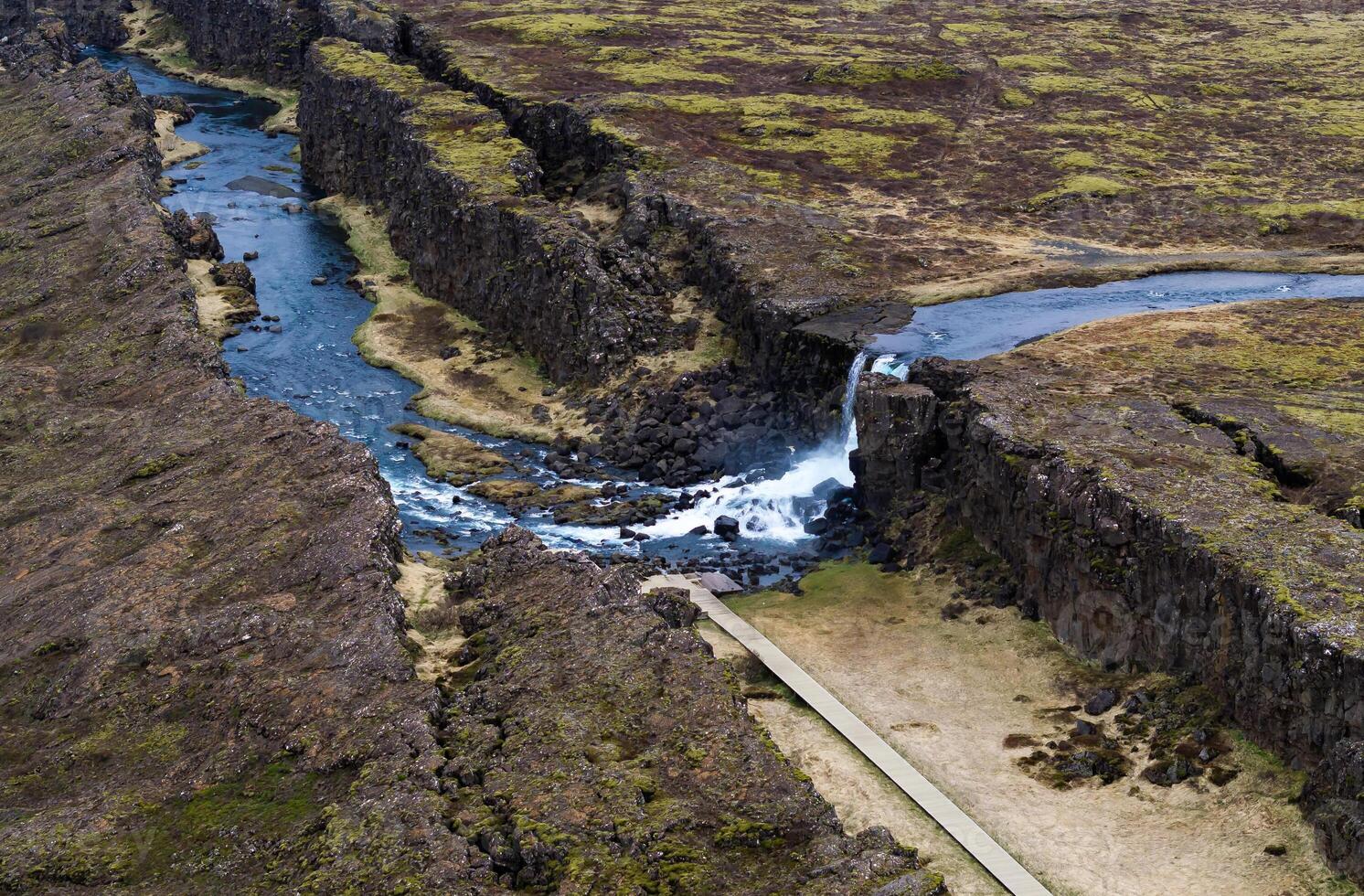 Aerial panorama of Oxarafoss waterfalls in Thingvellir National Park, Iceland, showcasing the Oxara River, the dramatic tectonic plates of America and Eurasia, and the stunning natural landscape. photo