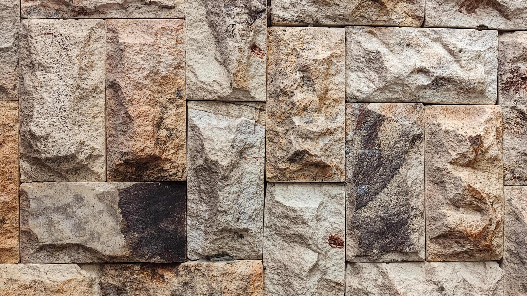 close-up view of a wall constructed with various sizes of rectangular stone blocks photo