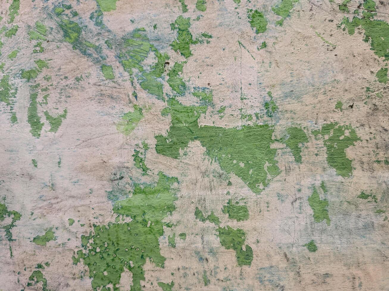 background with a close-up texture that resembles a map pattern with various green patches distributed across the beige background photo