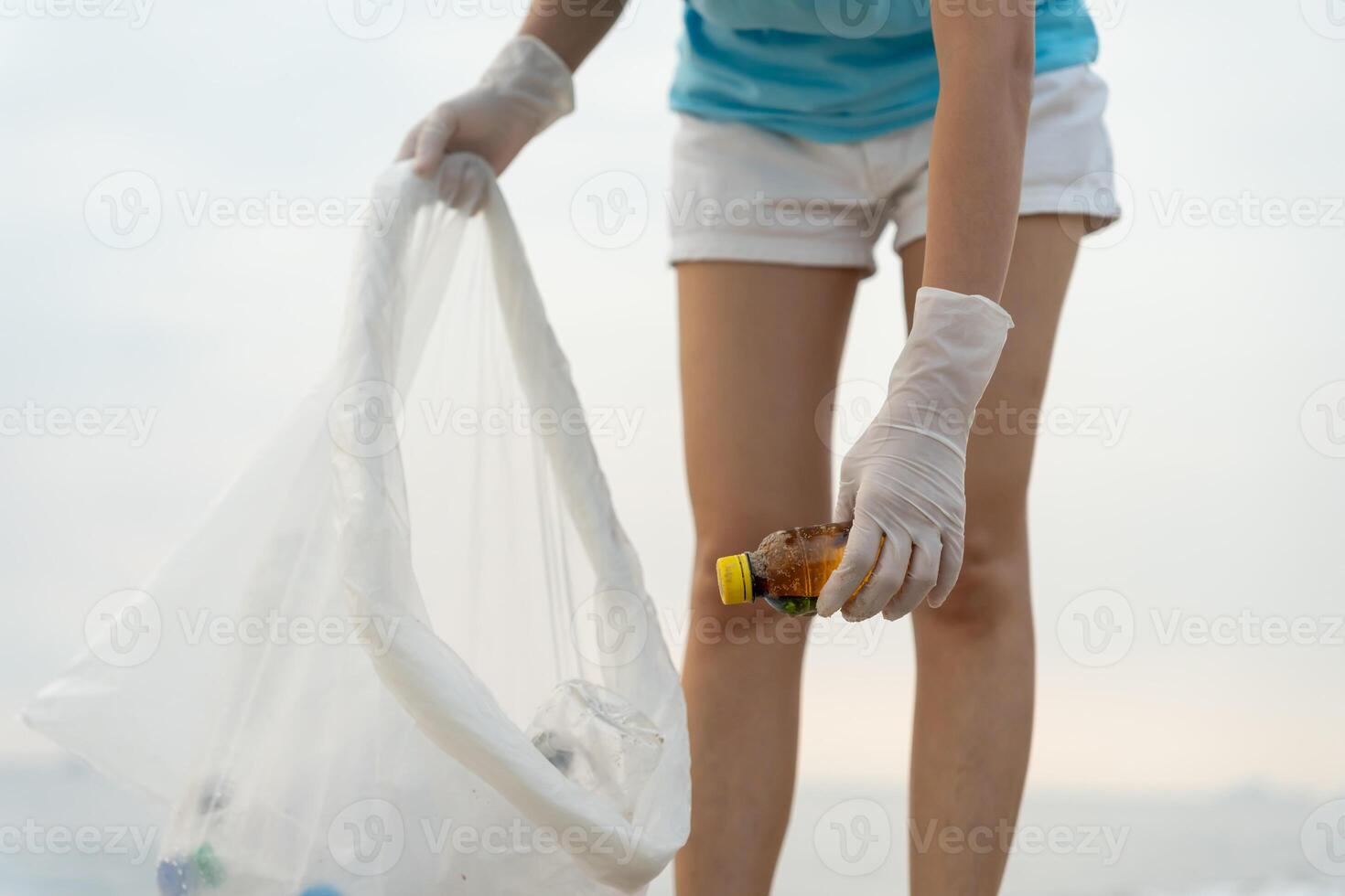 Save water. Volunteer pick up trash garbage at the beach and plastic bottles are difficult decompose prevent harm aquatic life. Earth, Environment, Greening planet, reduce global warming, Save world photo