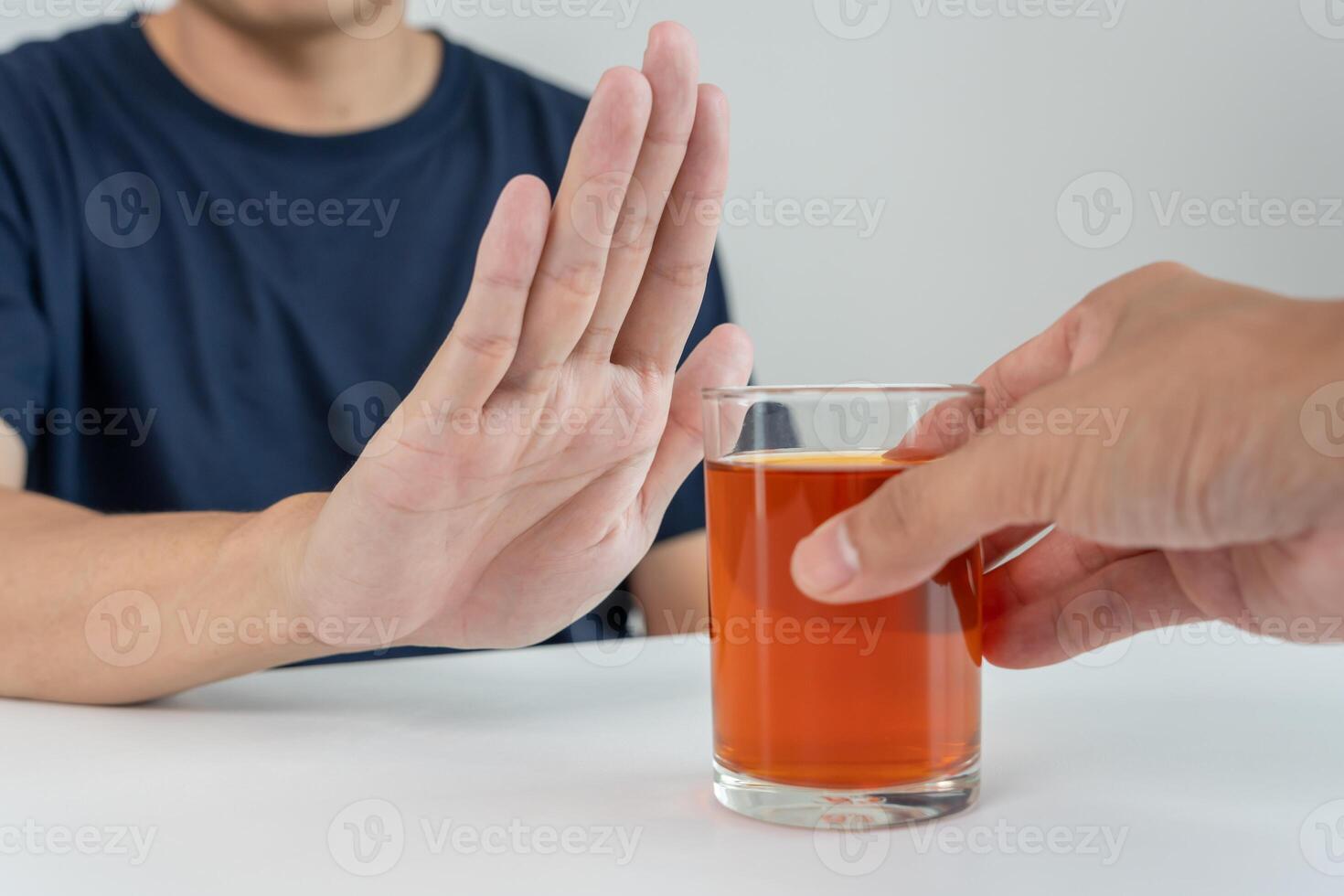 man refuses say no and avoid to drink an alcohol whiskey , stopping hand sign male, alcoholism treatment, alcohol addiction, quit booze, Stop Drinking Alcohol. Refuse Glass liquor, unhealthy, reject photo