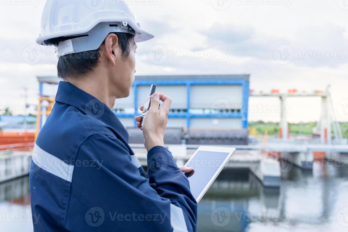 maintenance and inspector. Maintenance engineers are using walky talky to inform the results of inspection of buildings and structures. Irrigation engineers are exploring sluice systems photo