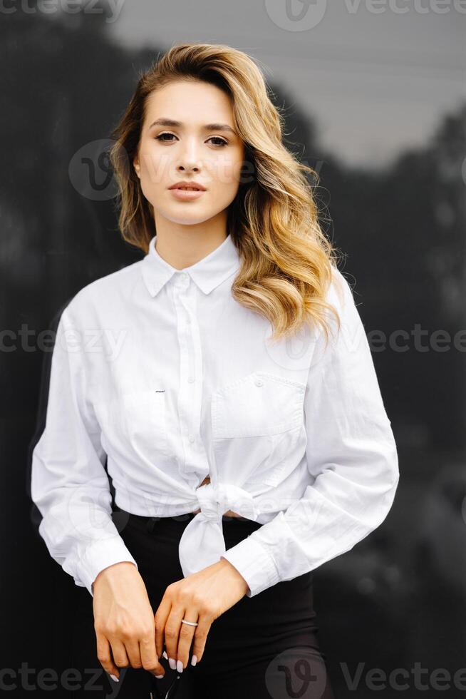 Businesswoman is standing at the corporate building. Confident caucasian woman in glasses is looking to the camera photo