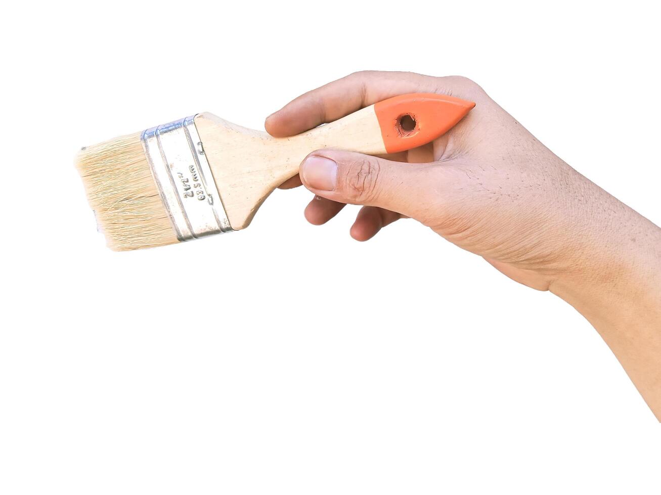 Hand holding yellow paint brush, close-up horizontal view, white background photo