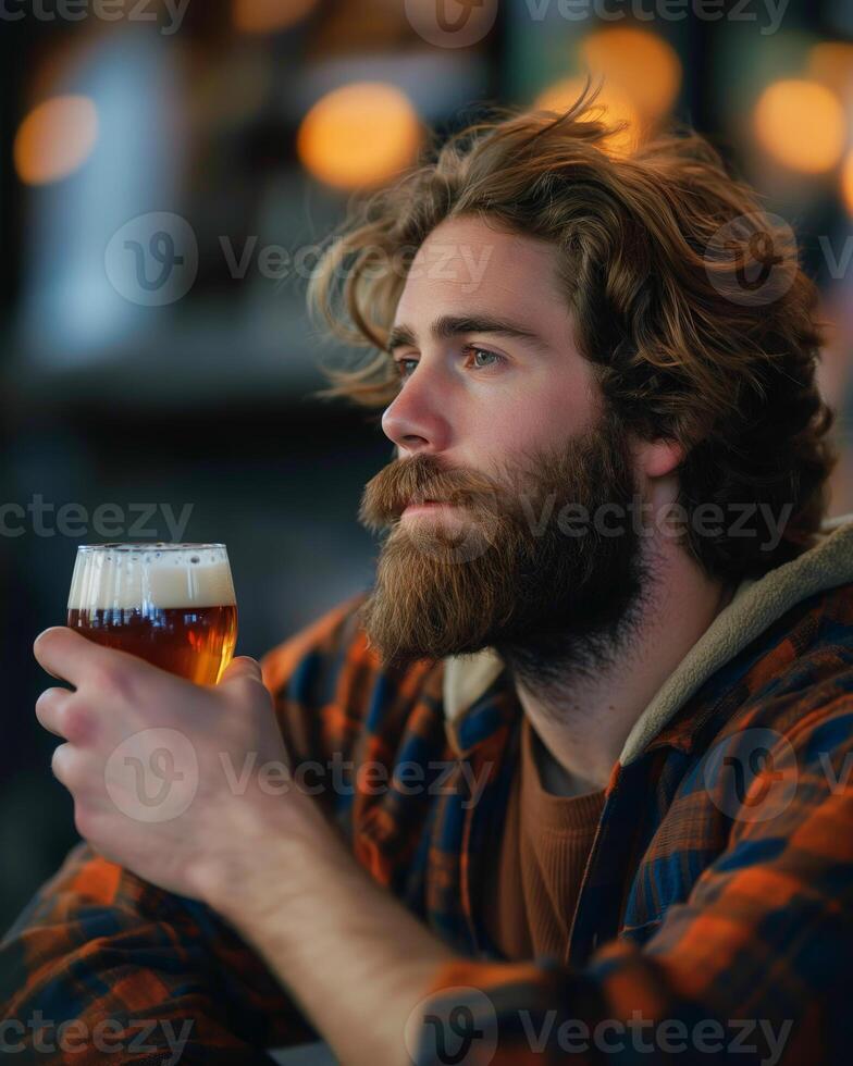 Contemplative Bearded Man Enjoying Craft Beer in Cozy Bar with Warm Lighting for Autumn Holidays, International Beer Day photo