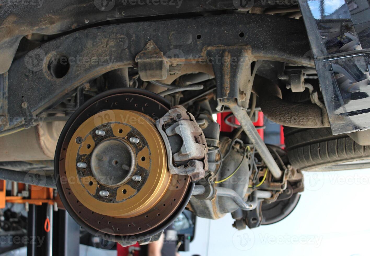 The brake system and disassembled rear suspension of a vehicle on a lift in a car repair shop. Brake pads replacement free royalty image photo