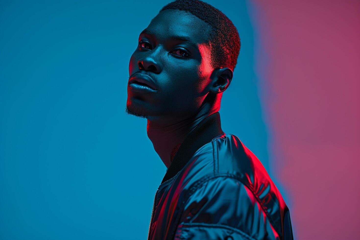 Fashionable male model in a casual bomber jacket with a neon blue background combining laid back style with vibrant neon hues for a contemporary and striking portrait photo