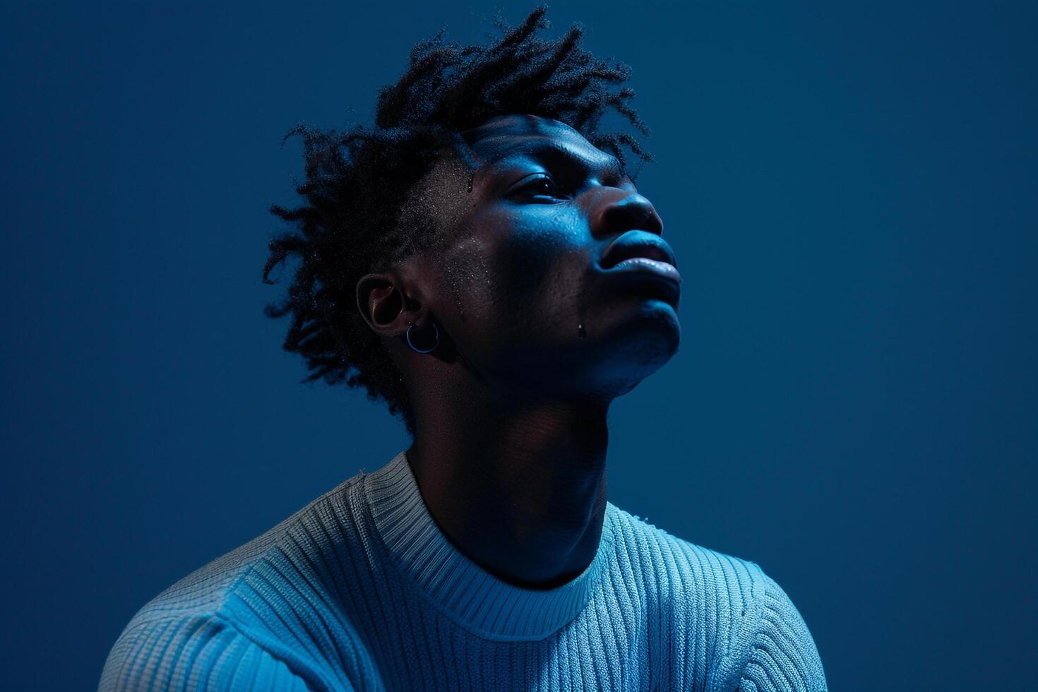 Males fashion featuring an indigo blue pullover highlighting a sophisticated lifestyle in a modern portrait with a matching background photo