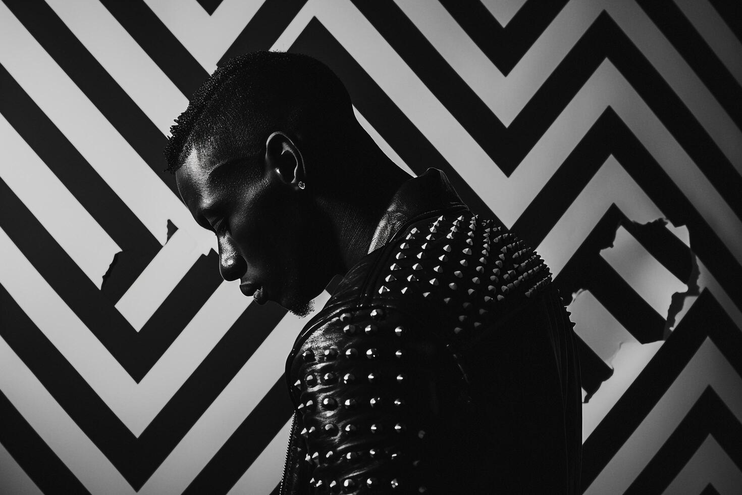 Fashionable male fashion model in studded jacket black and white stripes contemporary portrait photo