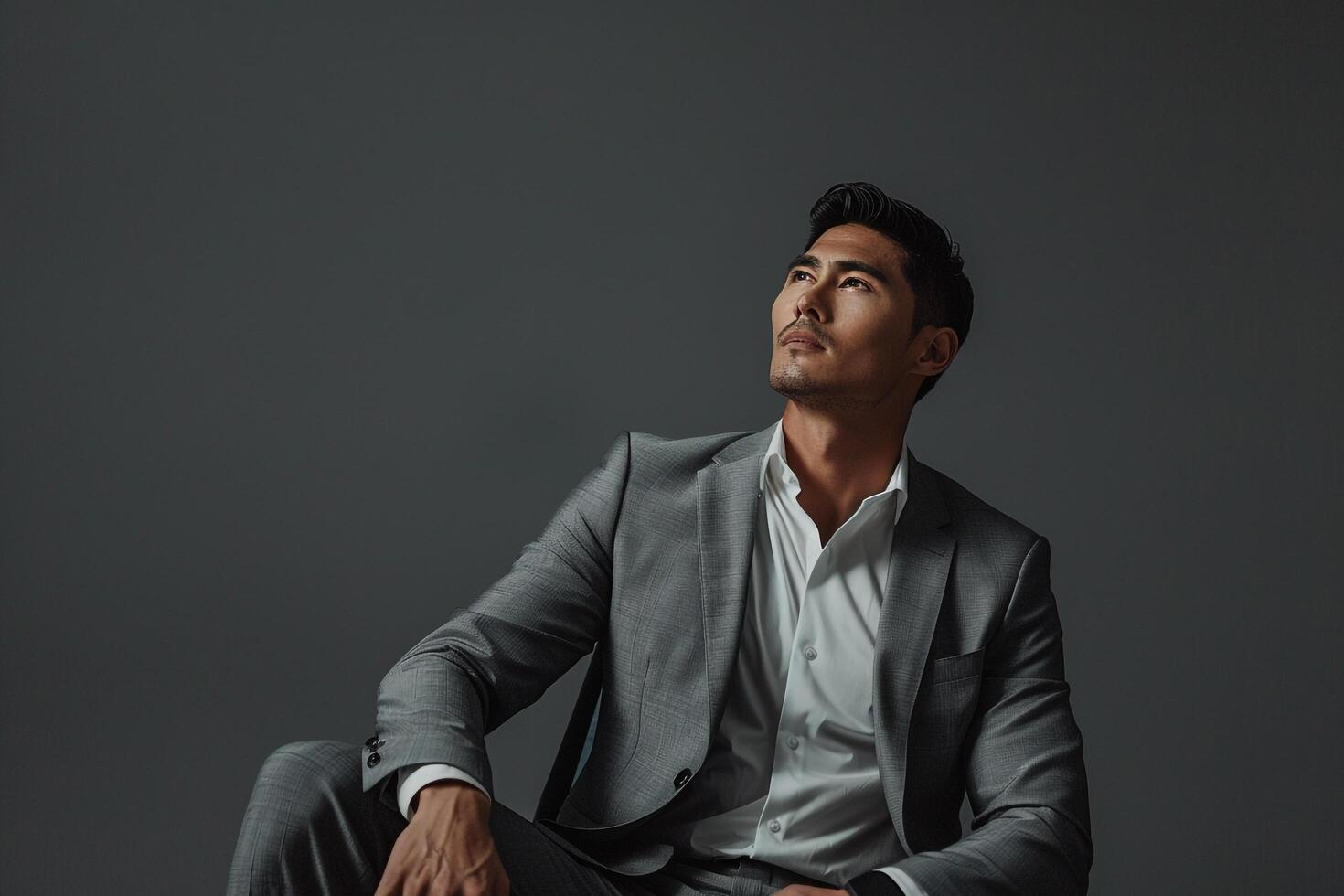 Trendy male model in a suit with a slate gray background contemporary portrait showcasing sophisticated and stylish Males fashion choices photo