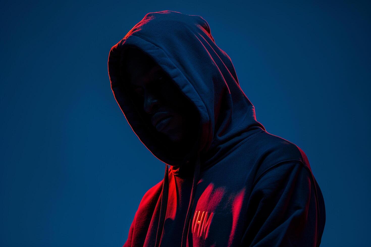 Trendy male fashion model in hoodie electric blue background stylish portrait showcasing urban fashion with a focus on contemporary style photo