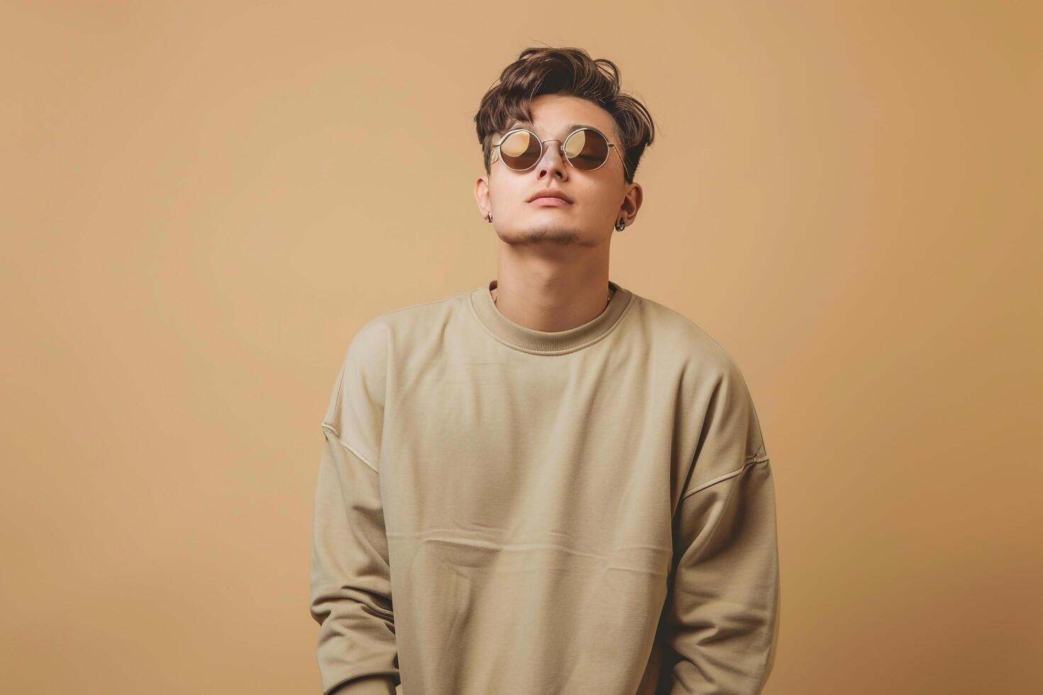 Handsome male model in light olive pullover sunglasses soft beige background fashionable portrait reflecting modern fashion and lifestyle eleMalets photo