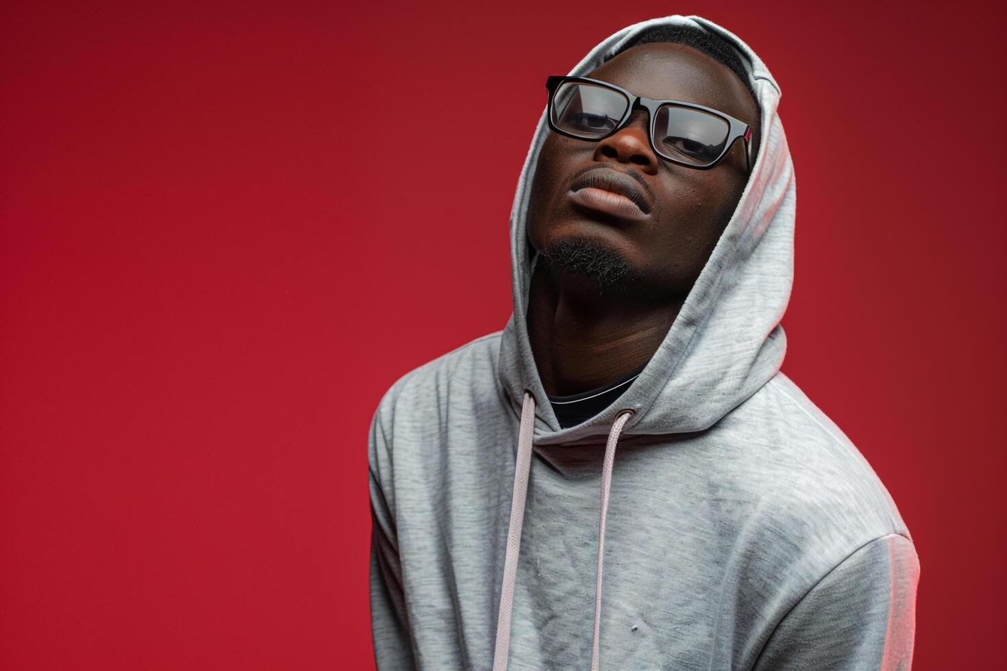 Stylish male model in hoodie and stylish square glasses deep rose background showcasing a chic and contemporary lifestyle portrait with a focus on modern fashion trends photo